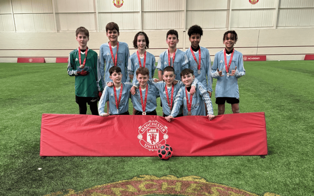 Year 7 boys from Priestnall School stand on the pitch after winning regional qualifiers of Manchester United Academy Emerging Talent competition