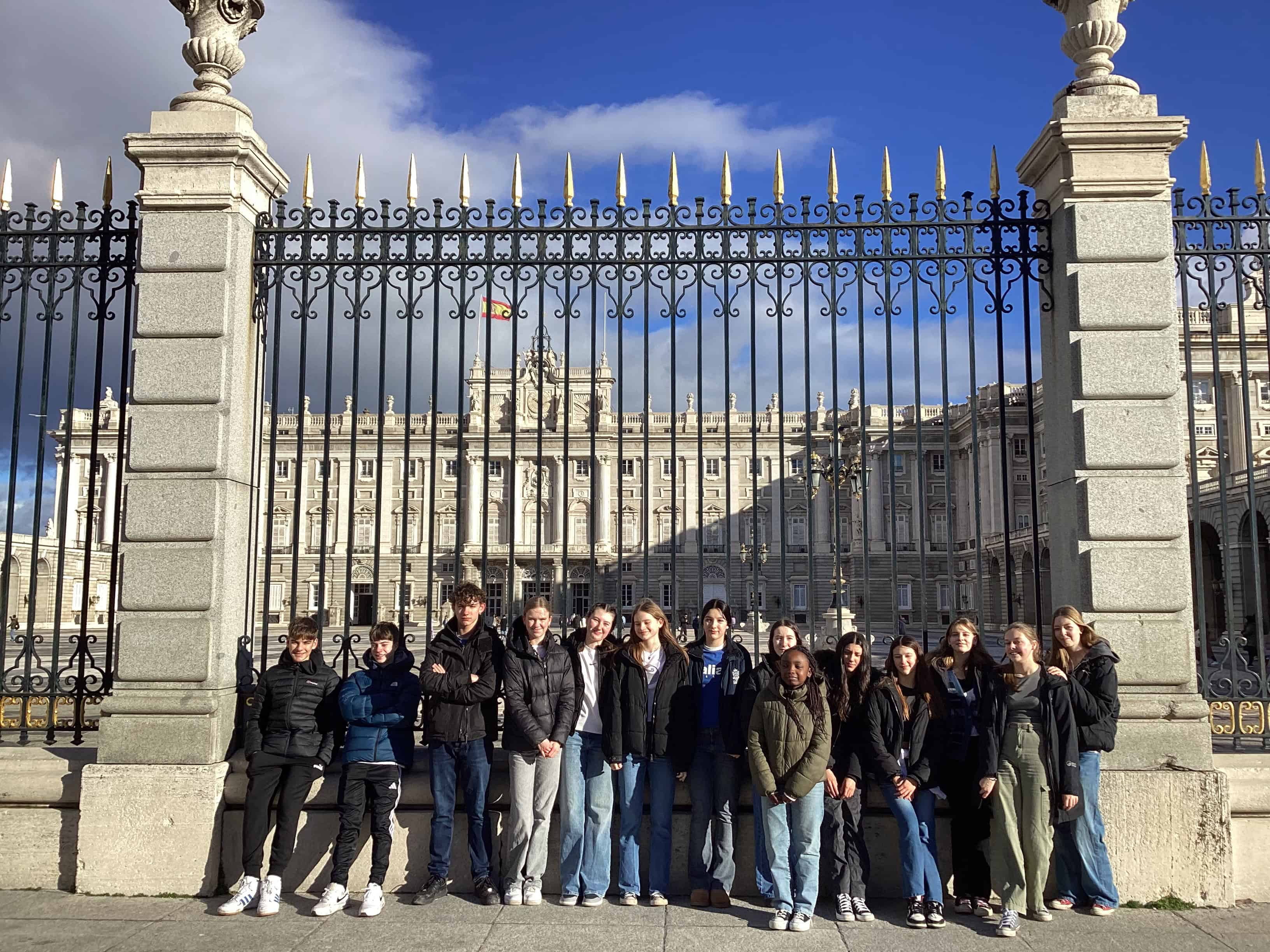 Students from Priestnall School stand in front of the gates of the Royal Palace of Madrid.