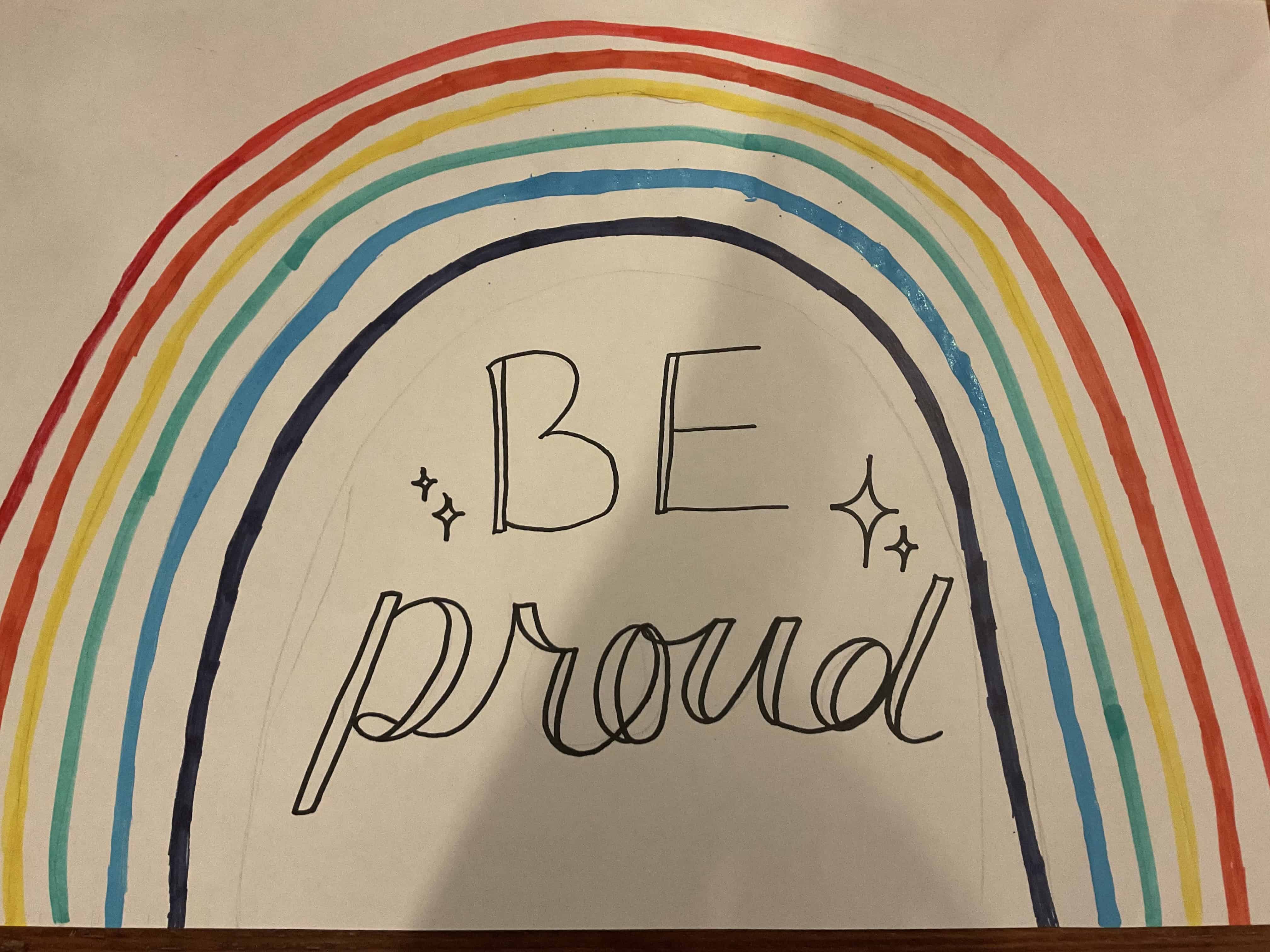 A drawing of a rainbow with the words 'Be proud' in the middle, drawn by a student at Priestnall School on the Pride trip 2025.