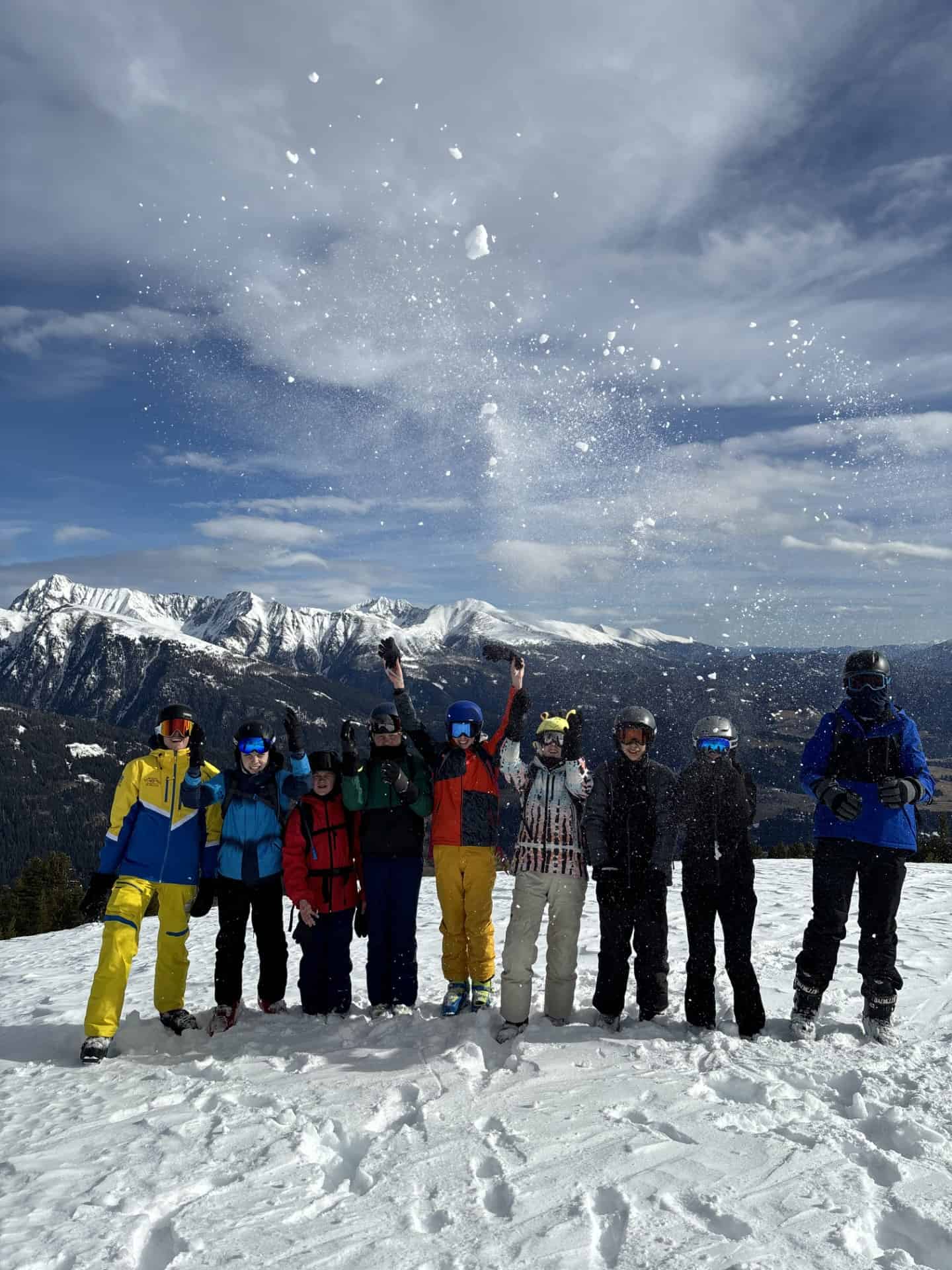 Students from Priestnall School stand in a line on a ski slope in Austria. 